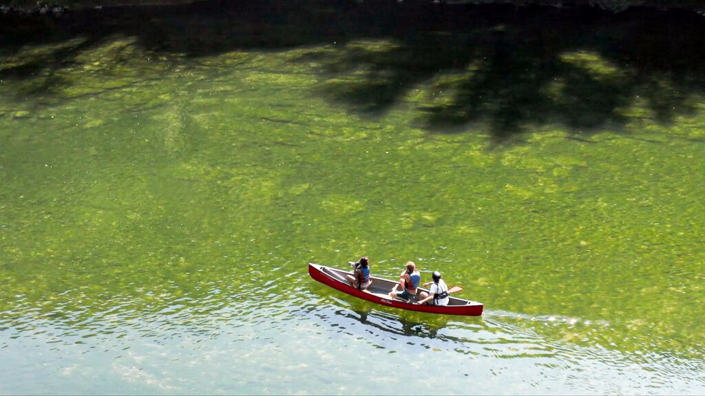 3 personnes dans un kayak rouge sur l'eau